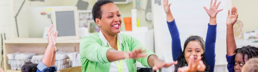 Children with hands up playing game with teacher